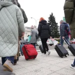 Varias personas con maletas, camino de la estación de ferrocarril. Rodrigo Jiménez